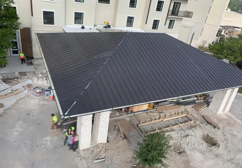 Metal roofing installation team working on a commercial building in Biloxi